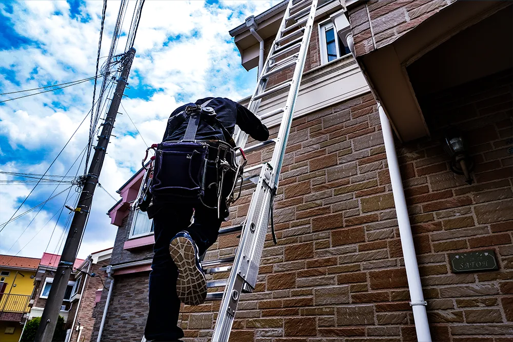 住宅の屋根状態を調査する一心建設の専門スタッフ